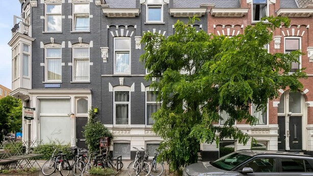A row of Victorian-style townhouses with bay windows, a tree in the foreground, and bicycles parked outside. - Bright Apartment With Private Terrace (Rotterdam)