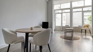 A modern room with a round table, four chairs, a TV, and large windows. - Bright Apartment With Private Terrace (Rotterdam)