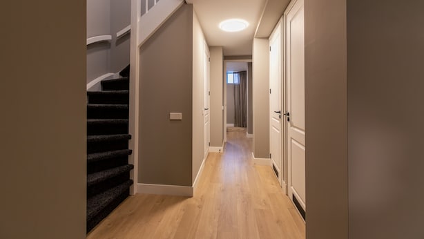 A hallway with a staircase, wooden flooring, and a door at the end. - Spacious Blijdorp Home With 4 Double Beds (Rotterdam)