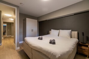 A modern bedroom with a large bed, a wardrobe, a bedside table, and a lamp. - Spacious Blijdorp Home With 4 Double Beds (Rotterdam)