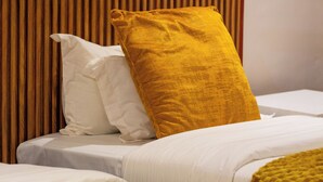 A hotel room with a bed, a headboard, and a folded towel on the bed. - Chiyedza Place (Juliasdale)