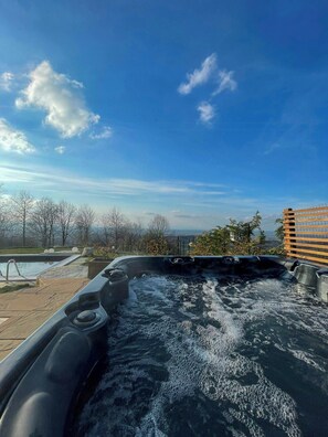 Ein Whirlpool mit Blick auf Pool und Bäume.