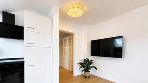 A modern kitchen with white cabinetry, a black oven, and a potted plant. - Sea Studio - Modern time-out right on the beach in Scharbeutz (Scharbeutz)