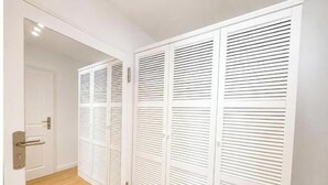 A white closet with sliding doors and a wooden floor. - Sea Studio - Modern time-out right on the beach in Scharbeutz (Scharbeutz)
