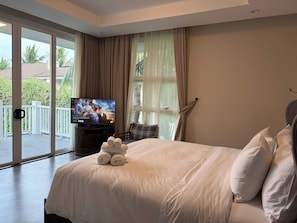 A hotel room with a bed, a television, and a view of the outside. - Da Nang Premier Villas Retreat by Hanah (Da Nang)
