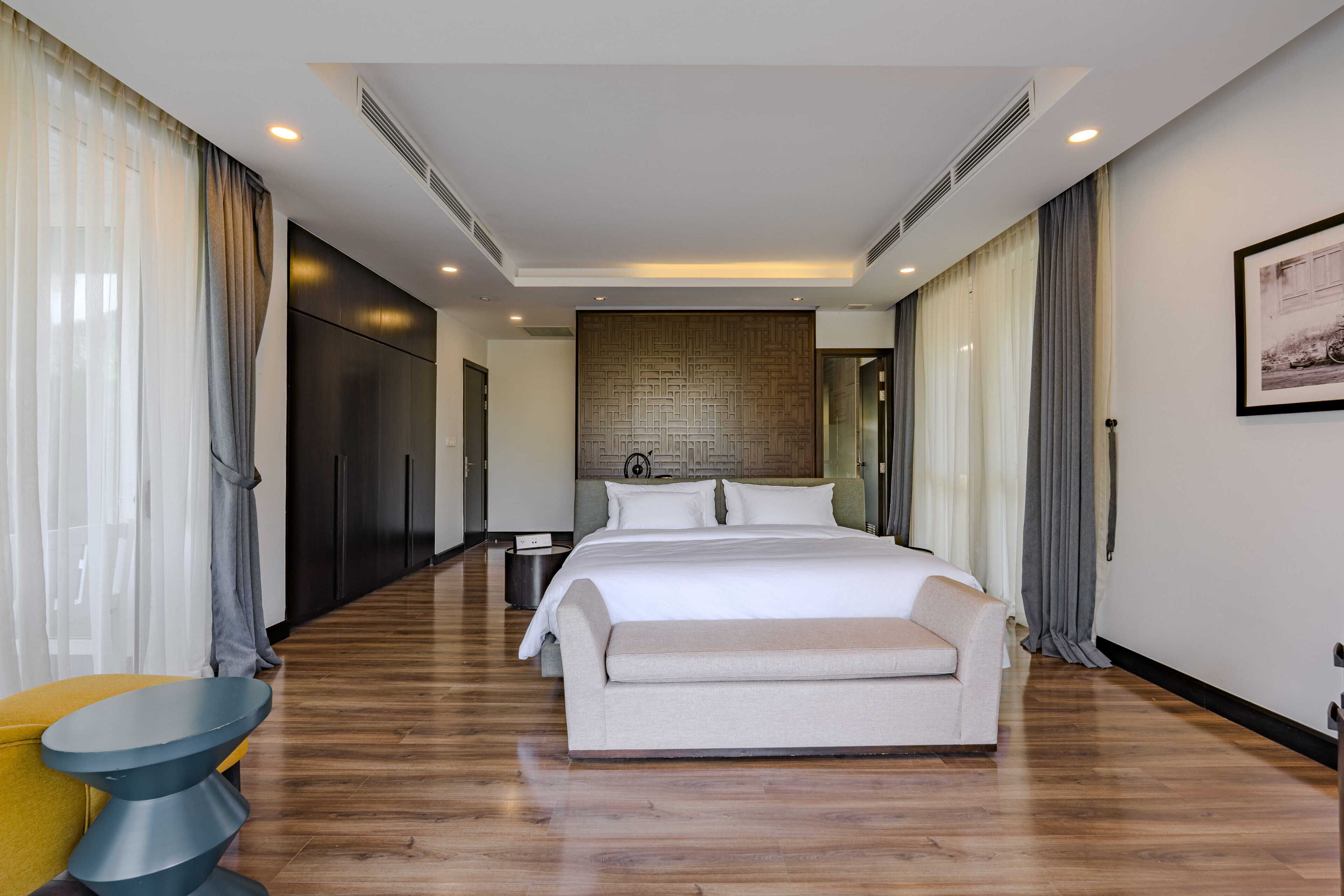 Une chambre d’hôtel moderne avec un grand lit, un canapé, une petite table et une chaise.