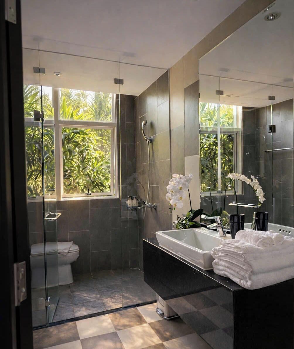 A modern bathroom with a glass shower enclosure, a large mirror, and a bathtub.