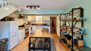 Eine moderne Küche mit weißen Schränken, einem Holztisch und einem eingebauten Backofen.