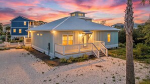 A coastal house with a porch, a staircase, and a palm tree. - Beach House - Coastal Cabana (Port St. Joe)