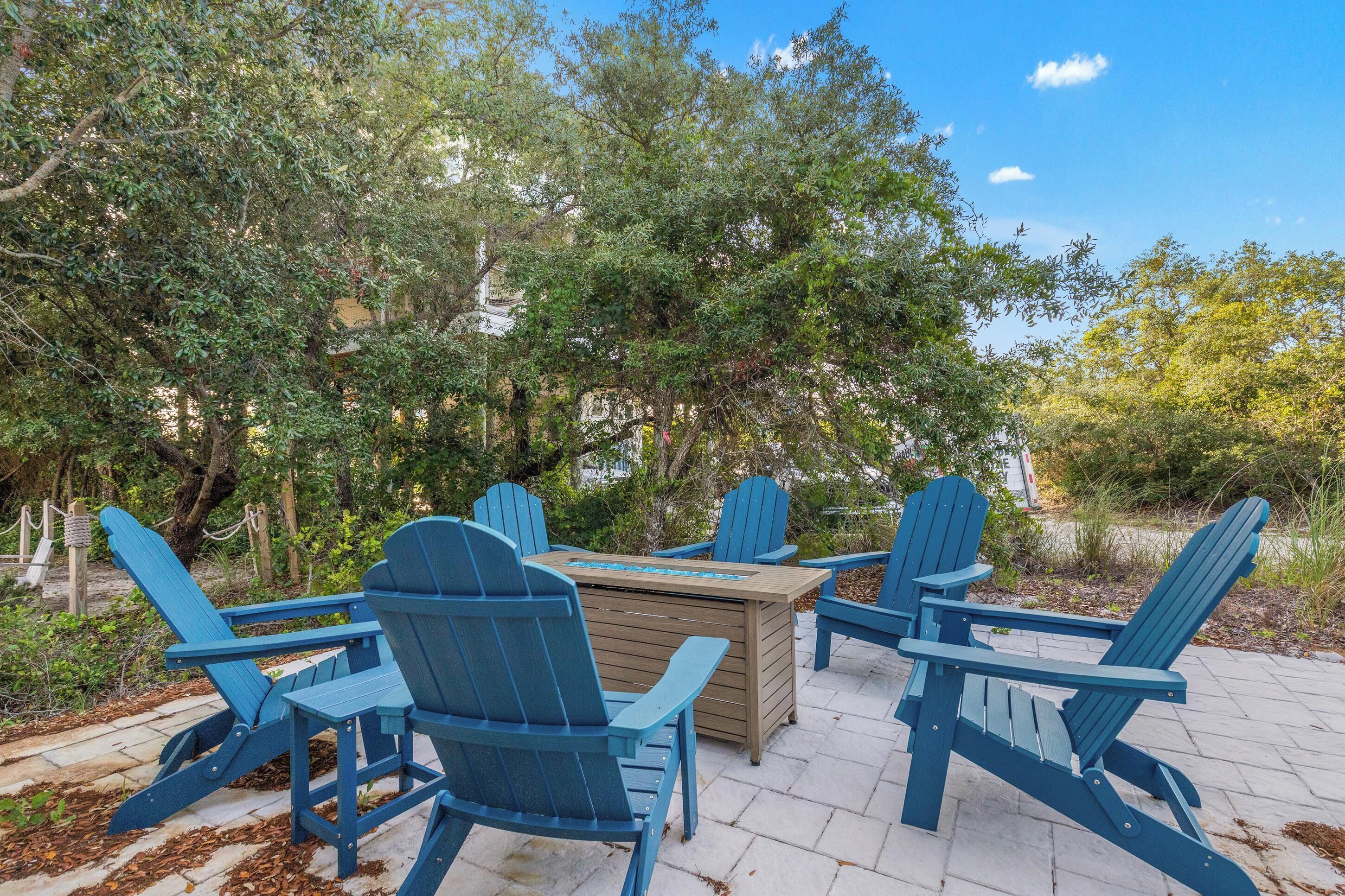 A wooden table with chairs in a garden setting.