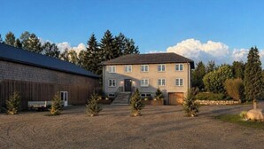 Un bâtiment à deux étages avec une allée gravillonnée et de petits arbres.