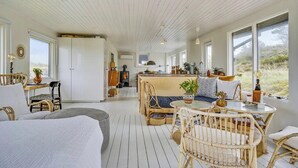 Een gezellig interieur van een blokhut met een eethoek, zitplaatsen en een keuken.