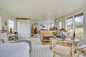 Ein gemütliches Blockhauss-Interieur mit Essbereich, Sitzgelegenheiten und einer Küche.