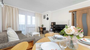 Un soggiorno moderno con divano, tavolo da pranzo e televisione.