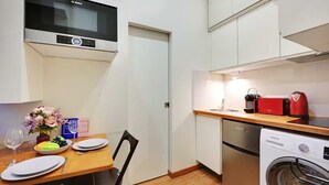 Una cocina compacta con un microondas Bosch, lavavajillas Siemens y un tostador rojo.