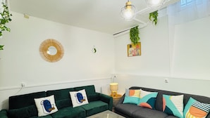 Een moderne woonkamer met twee banken, een glazen salontafel en hanglampen.