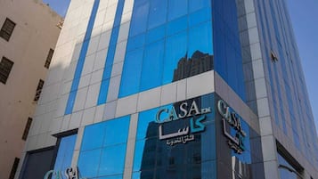 A modern building with reflective glass windows and a prominent 'CASA' sign.