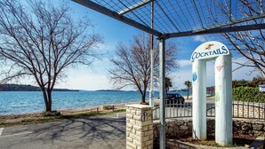 A sign for a place named 'COCKTAILS' with a view of a lake and trees. - Moretti Stay Near Vodice Center (Vodice)