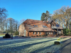 A large brick house with multiple windows and a sloped roof. - Romantic countryside in East Frisia (Friedeburg)