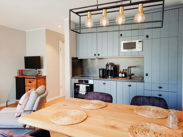 A modern kitchen with a built-in microwave, a coffee maker, and a sink. - Romantic countryside in East Frisia (Friedeburg)