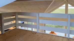 A room with wooden flooring, white walls, and a large window with a view of the outdoors. - Fresh air on open terrace with view (Hejls)