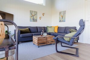 Ein Wohnzimmer mit einer Couch, einem Couchtisch und einem Sessel.