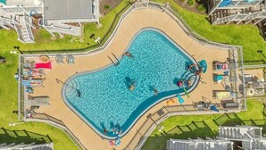 An aerial view of a swimming pool surrounded by a deck with lounge chairs and umbrellas. - Saltlife - Beachside Townhome - Pool - Just Steps from Beach (Mexico Beach)