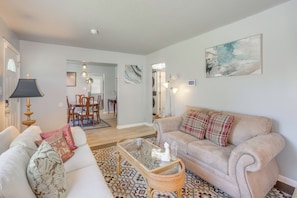 A living room with a sofa, a coffee table, and a patterned rug.