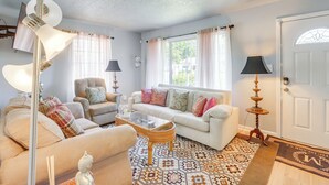 A living room with a sofa, armchairs, a coffee table, a floor lamp, and a door with a window. - Renovated Birmingham Cottage: Great Outdoor Space! (Birmingham)
