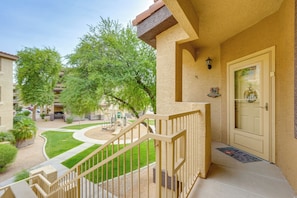 A residential building with a front entrance, a staircase, and a small garden area.