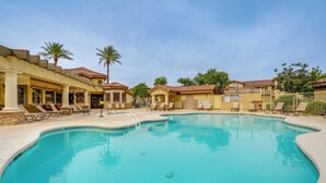 A swimming pool with lounge chairs, palm trees, and a building with a tiled roof. - Resort-style Pools & Hot Tubs! Mtn-view Mesa Condo (Mesa)