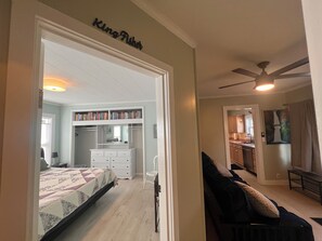 Ein Schlafzimmer mit einem Bett, einem Schminktisch, einem Bücherregal und einem Kleiderschrank.