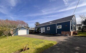 Ein Wohnhaus mit Garage, überdachter Veranda und gepflegtem Rasen.