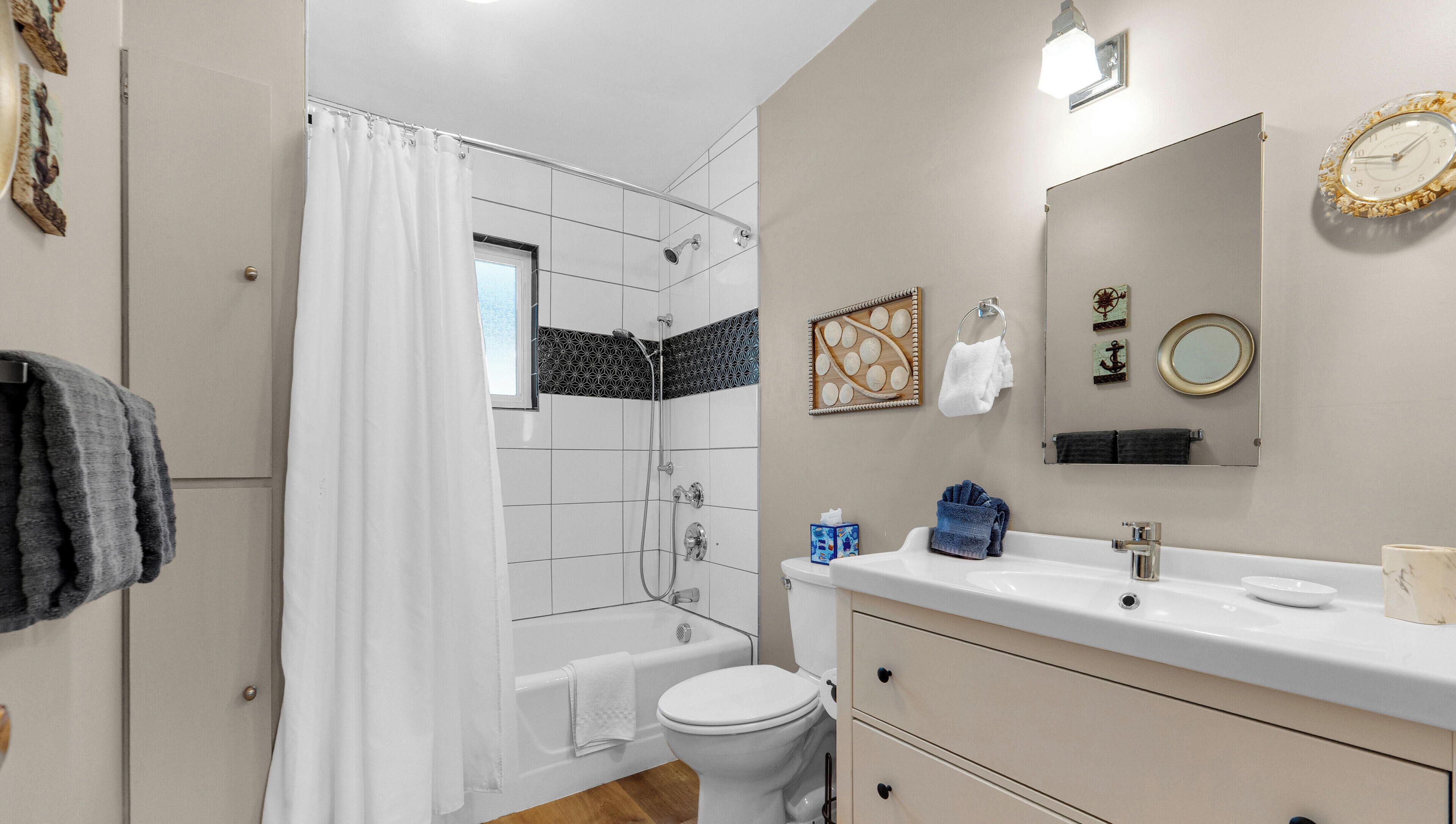 A modern bathroom with a shower, toilet, sink, and vanity.
