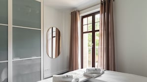 A hotel room with a bed, a wardrobe, a mirror, and a window with curtains. - Sopot Haffnera - close to the beach  (Sopot)