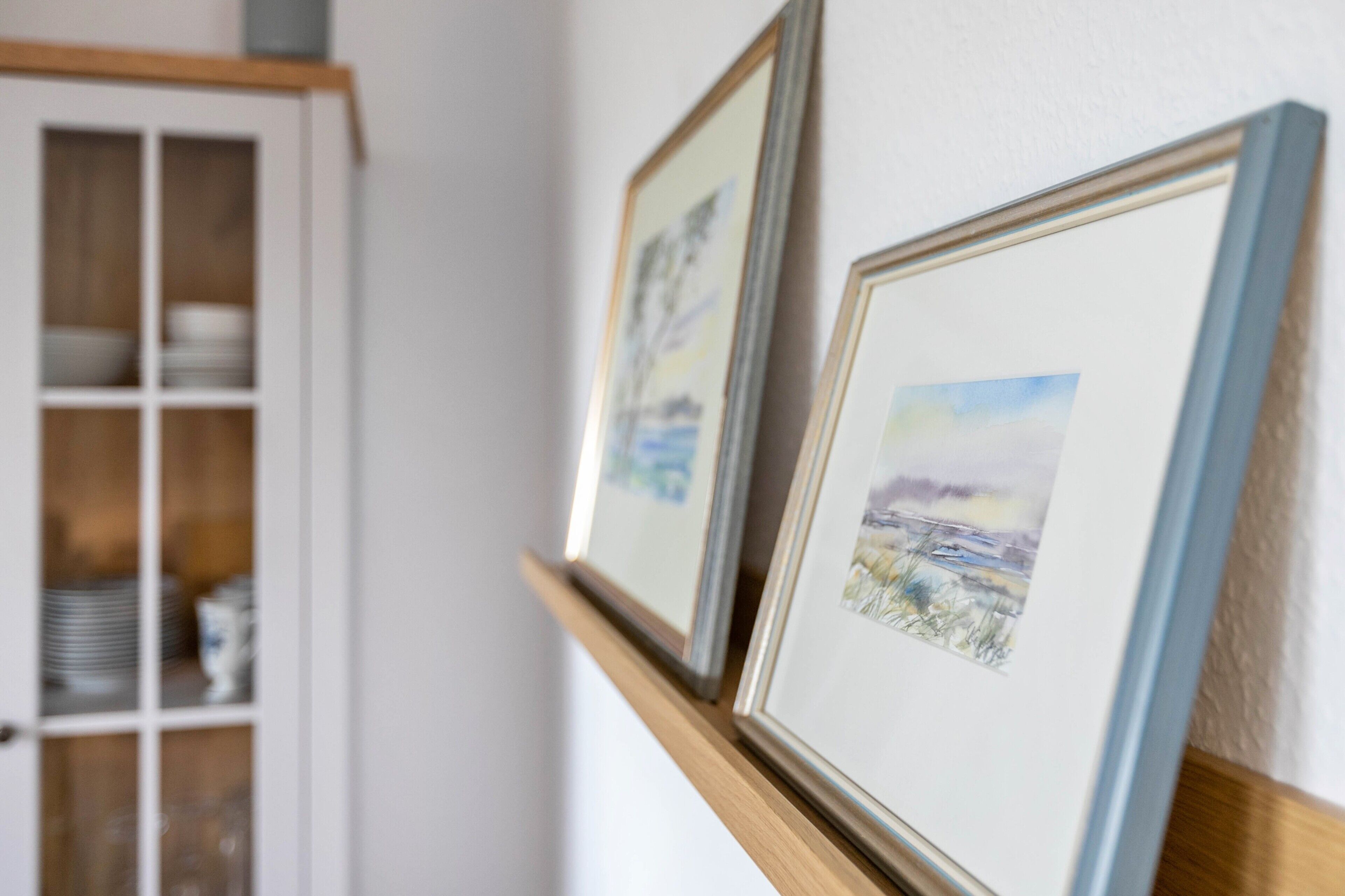 A wall with two framed pictures.
