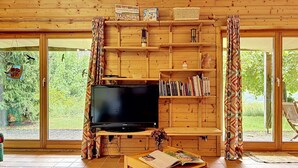 Une pièce aux murs lambrés, équipée d’un téléviseur, de bibliothèques et d’une table sur laquelle se trouve un magazine.