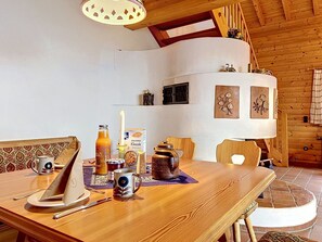 Ein Holztisch mit Kerze, einer Packung KNUSPER Klassik und verschiedenen Gewürzen.