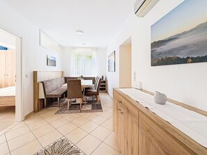 Eine moderne Küche mit Essbereich, Holzschränken und einem Gemälde an der Wand.