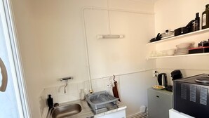 A compact kitchen with a sink, dish rack, and a coffee machine. - Les appartements de katia  (Charnay-lès-Mâcon)