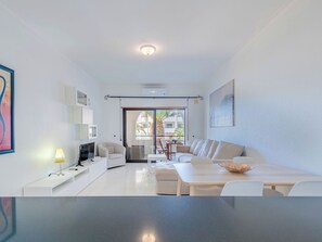 A modern living room with a sofa, a dining table, and a TV. - Be My Guest by Interhome (Porches)