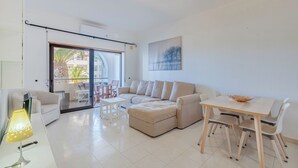 Ein modernes Wohnzimmer mit einer Couch, einem Esstisch und einem Balkon mit Blick.