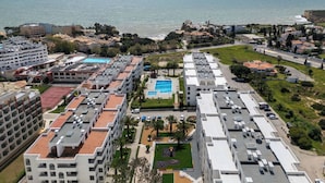Ein Küstenwohngebiet mit Mehrfamilienhäusern, einem Schwimmbad und Blick aufs Meer.
