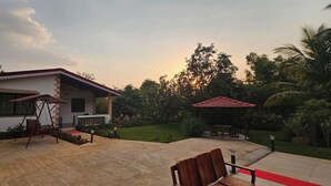 Ein Haus mit Terrasse, Schaukel und Laube.