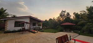 A house with a patio, a swing set, and a gazebo.