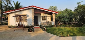 A two-story building with a red roof, a balcony, and a garden area. - Shambhala Lake View Villa Resort (Avate)