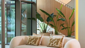 Un salon moderne avec un canapé, une table basse et des plantes en pot.