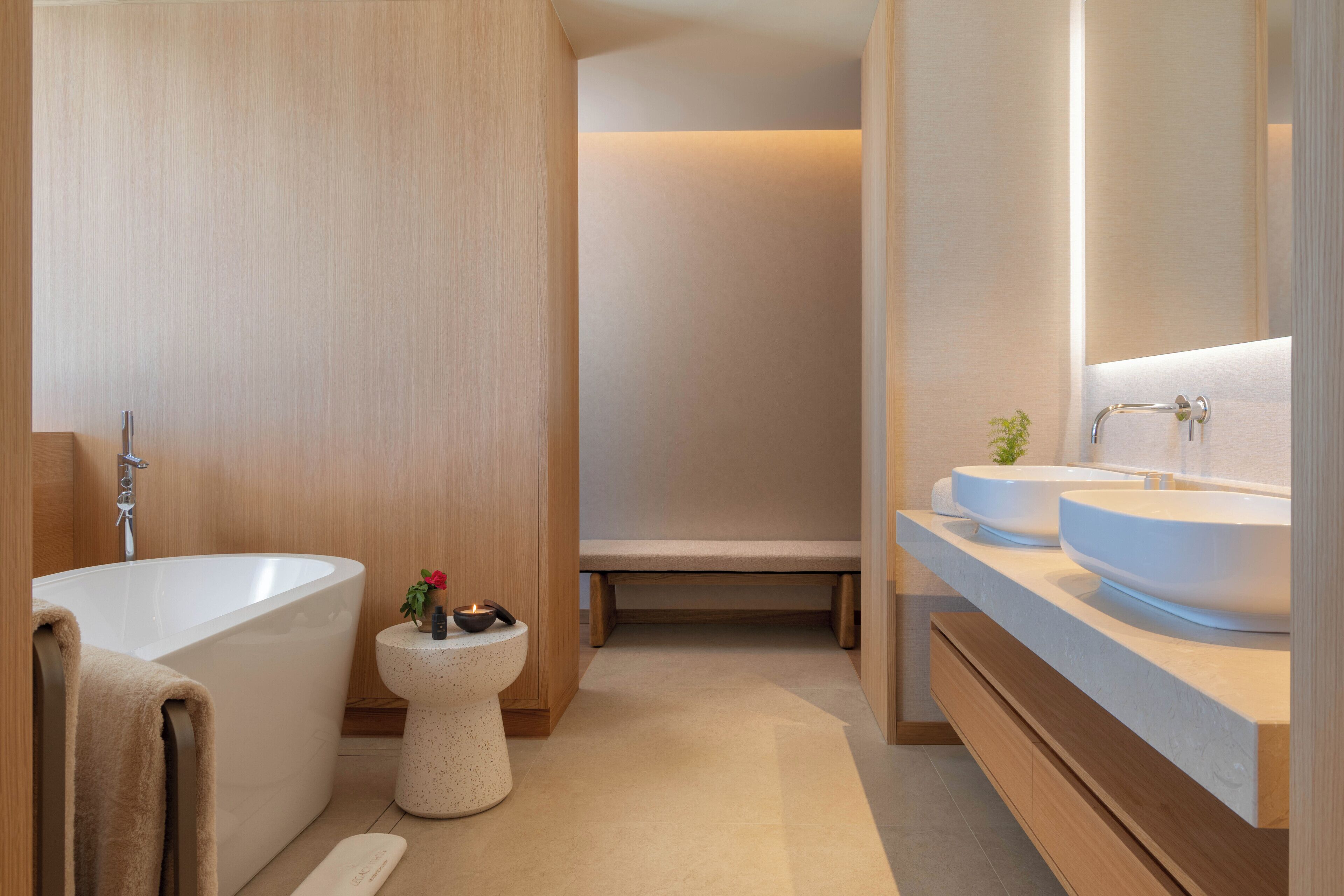 Une salle de bain moderne avec une baignoire sur pieds, des toilettes et un meuble-lavabo doté de deux vasques.
