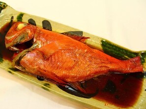 A whole roasted fish on a plate.