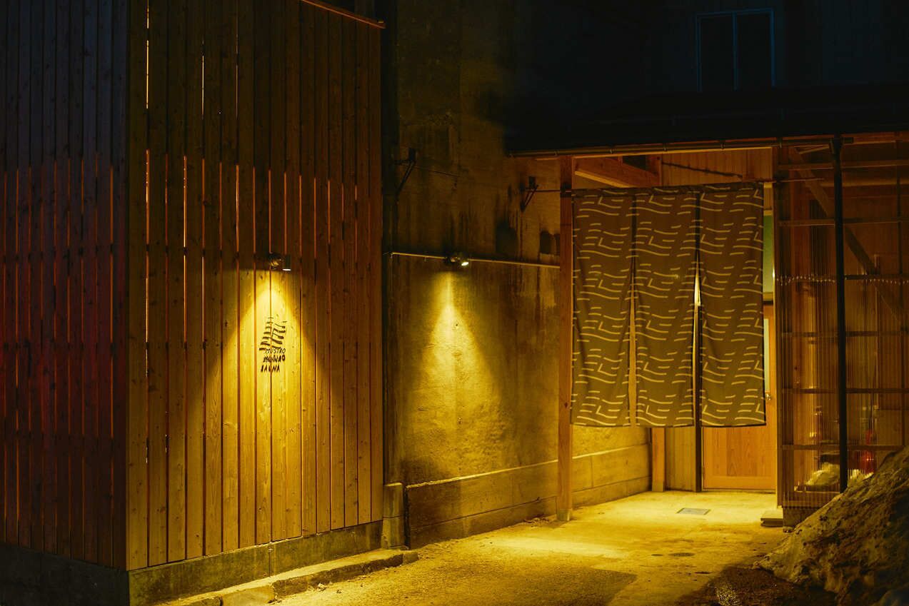 Un edificio de madera con puerta de madera y entrada de cristal.